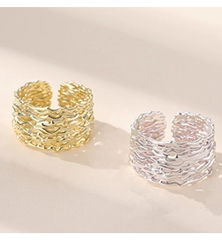 Macro shot of minimalist silver and gold open rings with irregular lava texture finish