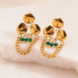Detailed close-up of golden flower tassel earrings with pearls and green malachite beads