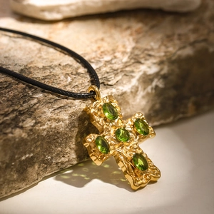 18k gold stainless steel cross necklace with five green gems on a black wax cord