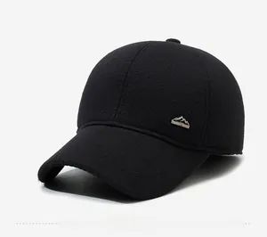 Detail of wool baseball cap with silver mountain metal badge on the side of black fabric