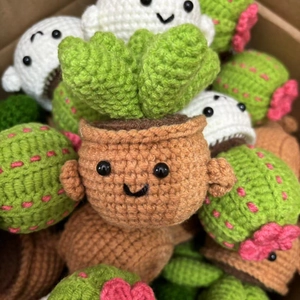 Close-up of handmade crochet mini potted plants with cute facial expressions and soft yarn texture