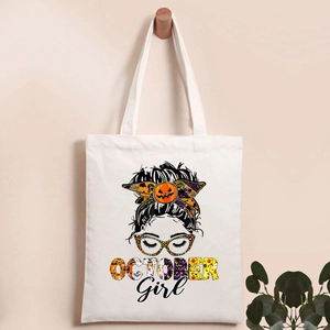 Close-up of Halloween tote bag showing pumpkin head print and OCTOBER Girl text detail