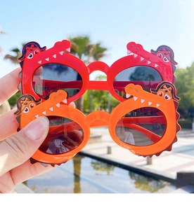 Close-up of cute crocodile shaped sunglasses in red and orange for kids 1-6 years