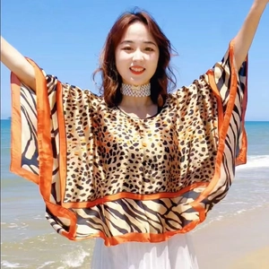 Nahaufnahme des leichten Leoparden-Ponchos mit orange-schwarzen Streifen am Saum