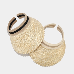 Close-up of straw sun visor texture with elegant black and beige striped ribbon detail