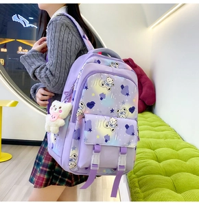 Detail of purple school backpack with astronaut bear print and plush toy accessory