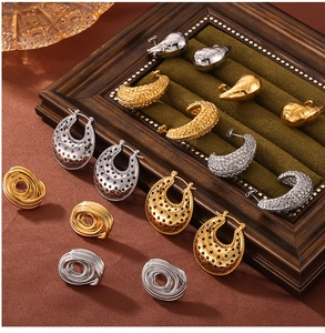 Detailed close-up of gold and silver statement earrings on velvet and wood display