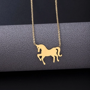 Detailed view of a golden unicorn pendant necklace displayed on a professional gray stand