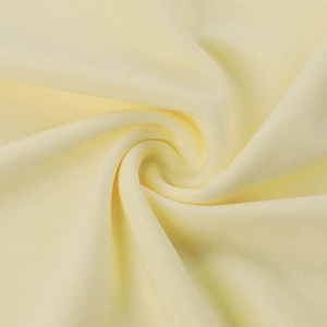 Close-up of pale yellow knit fabric showing soft texture and pleated ruffle details