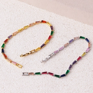 Close-up of gold and silver rainbow tennis bracelets with multi-color baguette zircons