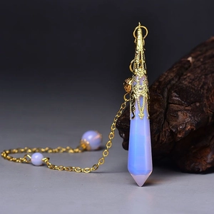 Macro shot of opal hexagonal pendant with intricate golden filigree cap and fine chain