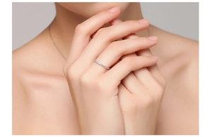 Close-up of minimalist thin silver eternity ring with sparkling diamonds on a hand