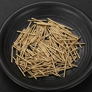 Industrial gold-plated brass electronic test pins and probe connectors in a bulk pile
