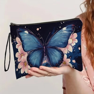 Blue butterfly floral makeup bag with zipper and hand strap held by a model