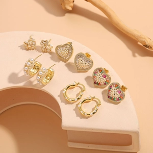 Vue macro de cinq paires de boucles d'oreilles dorées avec perles et pierres colorées
