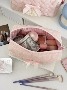 Pink heart quilted makeup bag set with lace bows and gingham lining on white desk