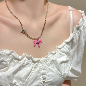 Dettaglio di una collana a sfere d'argento con ciondolo a forma di cavallo rosa e stella d'oro