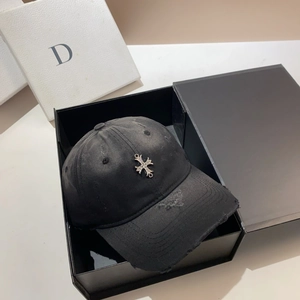 Close-up of distressed black baseball cap with silver metal cross and diamond inlay
