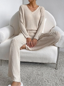 Detailed close-up of beige ribbed knit texture and V-neckline on women's two-piece set