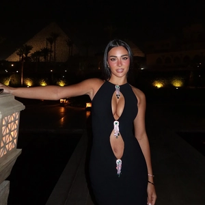 Détail de robe noire ajourée avec ornements métalliques en forme de gouttes de bijoux