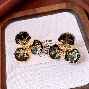 Vue macro de boucles d'oreilles vintage en émail noir avec centre en zircon brillant