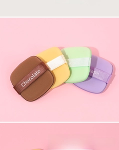 Detailed view of colorful makeup puffs with silk ribbons and soft texture for makeup