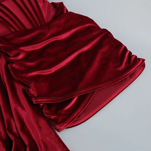 Détail du tissu en velours rouge montrant une texture riche et des plis élégants