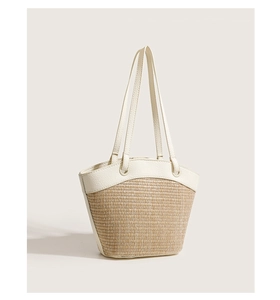 Close-up of woven straw texture and white PU leather trim on this beach tote bag