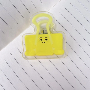 Detailaufnahme der gelben Acryl-Vielzweckklammer mit Smiley auf kariertem Papier