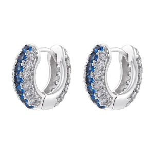 Macro view of silver hoop earrings with blue and white zircons in pave setting