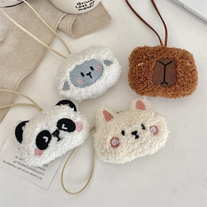 Set di quattro ciondoli per borsa in peluche: capibara, pecora, panda e gatto sul tavolo