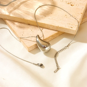 Detailed shot of silver water drop necklace with S.STEEL stamp on lobster clasp closure