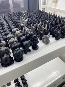 Detailed row of matte black obsidian-style puppy figurines on a storage rack