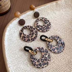 Vintage leopard print acrylic resin hoop earrings with amber beads on a ceramic tray