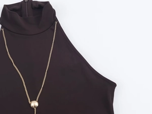 Close-up of high neck sleeveless dress with gold chain detail and metallic beads