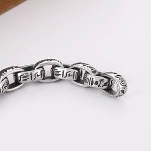 Detailed close-up of retro silver punk chain bracelet with ancient Egyptian hieroglyphic icons