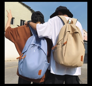 Outdoor shot of light blue and khaki large capacity backpacks worn by models