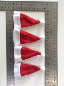 Set of four mini red velvet Christmas hats with dimensions shown next to a steel ruler