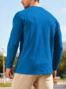 Close-up of blue waffle knit texture and buttoned raglan sleeve on men's casual shirt