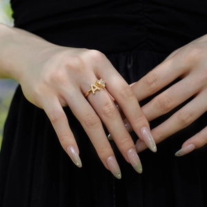 Close-up of model wearing adjustable golden A-letter and heart zircon open ring