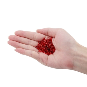 Hand holding red cylindrical Czech glass bugle beads for DIY jewelry making