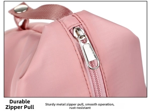 Close-up detail of smooth metal zipper and durable handle on pink gym travel bag
