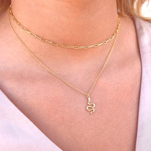 Close-up of a golden double-layered necklace featuring a creative snake pendant on a model