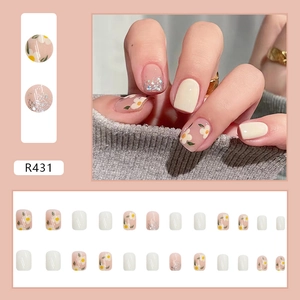 Set di unghie finte con fiori di camelia bianchi e glitter argentati in rosa tenue