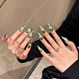 Green metallic stiletto press-on nails with marble texture and hand-painted python pattern