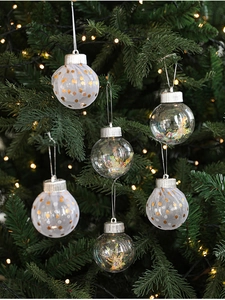 Christmas tree ornaments with sequins and white mesh hanging on a festive decorated pine tree