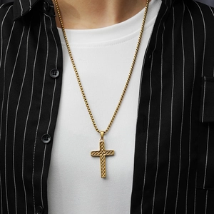 Close-up of golden Celtic cross pendant with intricate woven texture on round box chain