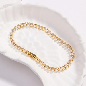 Goldenes Tennisarmband mit weißen Marquise-Zirkonia auf einer Muschelschale