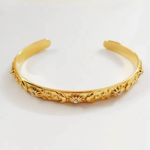 18K gold plated stainless steel open bangle featuring celestial sun moon star motifs