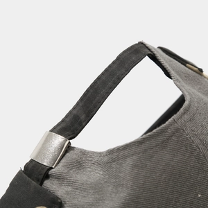Detailed view of adjustable silver metal buckle and black strap on a dark gray beanie